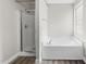 Bright bathroom featuring walk in shower and a separate soaking tub with a window at 202 River Hills Dr, Clayton, NC 27527