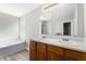 Bathroom featuring a double sink vanity, and a separate soaking tub with a window at 202 River Hills Dr, Clayton, NC 27527