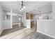 Open-concept living room features light gray walls, updated wood flooring, and modern lighting fixture at 202 River Hills Dr, Clayton, NC 27527