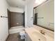 Modern bathroom features a shower-over-tub, and a large mirror above the vanity sink at 208 Acorn Crossing Rd, Holly Springs, NC 27540