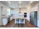 Bright, open kitchen featuring stainless steel appliances, center island seating, and stylish pendant lighting at 208 Acorn Crossing Rd, Holly Springs, NC 27540