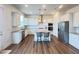 A bright, open kitchen with stainless steel appliances, a center island with seating, and wooden floors at 208 Acorn Crossing Rd, Holly Springs, NC 27540