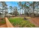 Expansive backyard featuring a fire pit, mature trees, lawn, and a wooden fence, perfect for outdoor enjoyment at 209 Falcon Ct, Clayton, NC 27520