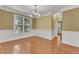 Spacious living room featuring hardwood floors, white trim, chandelier, and natural light, perfect for entertaining at 2224 Cedar Grove Dr, Durham, NC 27703