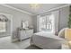 Light-filled bedroom with large window, neutral colors, and elegant chandelier at 2401 Chianti Ct, Apex, NC 27502