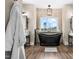Stylish bathroom with a modern soaking tub and a large window with a private view at 2418 Crossroads Ave, Hillsborough, NC 27278