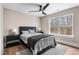 Neutral bedroom with a ceiling fan, wood floors, and a large window with a treed view at 2418 Crossroads Ave, Hillsborough, NC 27278