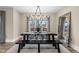 Elegant dining room boasts a decorative mirror, contemporary chandelier, and serene backyard views at 2418 Crossroads Ave, Hillsborough, NC 27278