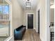 Inviting entryway features a storage bench, black doors, modern light fixture, and sleek flooring at 2418 Crossroads Ave, Hillsborough, NC 27278