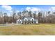 Elegant white two-story house with a spacious front yard and a three car garage at 2418 Crossroads Ave, Hillsborough, NC 27278