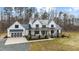 Charming two-story modern farmhouse with black framed windows, metal roof, and an attached garage at 2418 Crossroads Ave, Hillsborough, NC 27278
