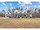 Stunning two-story white farmhouse with a welcoming front porch and well-manicured lawn at 2418 Crossroads Ave, Hillsborough, NC 27278