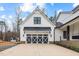 Attached garage featuring carriage doors on a charming two-story modern farmhouse at 2418 Crossroads Ave, Hillsborough, NC 27278