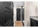 Hallway featuring wood floors and a glass enclosed shower with contrasting black doors at 2418 Crossroads Ave, Hillsborough, NC 27278