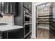 Modern kitchen with built-in stainless steel double ovens, a gas range, and a walk-in pantry with storage shelves at 2418 Crossroads Ave, Hillsborough, NC 27278