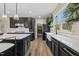 Spacious kitchen features a large island, black cabinets, stainless steel appliances, pantry, and a farmhouse sink at 2418 Crossroads Ave, Hillsborough, NC 27278