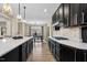 Stylish kitchen featuring gas range, decorative backsplash, and sleek, dark cabinetry, connecting to the dining room at 2418 Crossroads Ave, Hillsborough, NC 27278