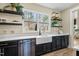 The kitchen features a large window, farmhouse sink, stainless steel dishwasher, and sleek, black cabinets at 2418 Crossroads Ave, Hillsborough, NC 27278
