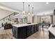 Open concept kitchen with a large island, stone accents, and views into the living and dining areas at 2418 Crossroads Ave, Hillsborough, NC 27278