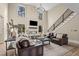 Stylish living room with tall stone fireplace, comfortable seating, and a modern staircase at 2418 Crossroads Ave, Hillsborough, NC 27278