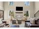 Bright living room showcasing a stone fireplace, wooden stools, hardwood floors, and stylish leather seating at 2418 Crossroads Ave, Hillsborough, NC 27278