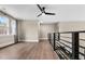 Open loft area with wood floors, a ceiling fan, and a modern iron railing at 2418 Crossroads Ave, Hillsborough, NC 27278