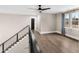 An open loft area with hardwood floors, modern railings, and a view of trees at 2418 Crossroads Ave, Hillsborough, NC 27278