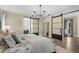 Stylish bedroom with a decorative bedspread, modern chandelier, and sliding doors leading to the bathroom at 2418 Crossroads Ave, Hillsborough, NC 27278