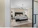 Luxurious main bedroom featuring stone accent wall, chandelier, lots of natural light, and modern flooring at 2418 Crossroads Ave, Hillsborough, NC 27278