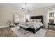 Luxurious main bedroom featuring stone accent wall, chandelier, lots of natural light, and modern flooring at 2418 Crossroads Ave, Hillsborough, NC 27278