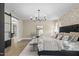 The main bedroom features an elegant chandelier, wood floors, and a decorative stone wall at 2418 Crossroads Ave, Hillsborough, NC 27278