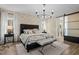 Luxurious main bedroom featuring stone accent wall, chandelier, lots of natural light, and modern flooring at 2418 Crossroads Ave, Hillsborough, NC 27278