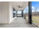 Inviting covered porch with comfortable swing, ceiling fan, and black metal railing offering outdoor relaxation at 2418 Crossroads Ave, Hillsborough, NC 27278