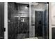 Luxurious shower with dark marble-look tile, a glass door and a convenient built-in niche at 2418 Crossroads Ave, Hillsborough, NC 27278