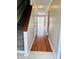 Hallway with hardwood floors leads to patio doors, with carpeted stairs on the left at 250 S Estes S Dr # Apt 113, Chapel Hill, NC 27514