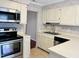 Well-lit kitchen featuring stainless steel appliances, tile floor, and neutral countertops at 250 S Estes S Dr # Apt 113, Chapel Hill, NC 27514