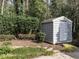 Backyard shed with mature landscaping, offering practical storage and blending into the natural setting at 2512 Winterbury Ct, Raleigh, NC 27607