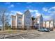 Apartment building with assigned parking, surrounded by greenery and a clear sky, providing a serene living environment at 2520 Friedland Pl # 102, Raleigh, NC 27617