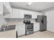 Well-equipped kitchen with stainless steel appliances, white cabinets, and tile flooring at 2520 Friedland Pl # 102, Raleigh, NC 27617