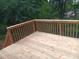 A wood deck with stained wooden railing overlooks the wooded backyard at 262 Tillamook Dr, Wake Forest, NC 27587