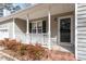 Inviting front porch with white railing, brick steps, and a view of the home's exterior and surrounding landscape at 262 Tillamook Dr, Wake Forest, NC 27587