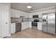 Modern kitchen with white cabinets, stainless steel appliances, granite countertops, and wood flooring, offering style at 262 Tillamook Dr, Wake Forest, NC 27587