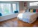 Sunlit bedroom featuring hardwood floors, and a large window seat with serene wooded views at 2819 Meacham Rd, Chapel Hill, NC 27516