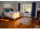 Spacious bedroom with hardwood floors, large window, and comfortable furnishings at 2819 Meacham Rd, Chapel Hill, NC 27516
