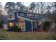 Back of house with plenty of windows showing light from inside. Backyard on a small hill at 2819 Meacham Rd, Chapel Hill, NC 27516