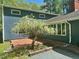 Blue house featuring a brick patio and flowering tree in a well-maintained yard at 2819 Meacham Rd, Chapel Hill, NC 27516