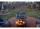 Cozy fire pit area with stone pavers, seating, and a lit fire, perfect for outdoor gatherings at 2819 Meacham Rd, Chapel Hill, NC 27516