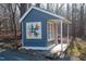 Charming blue playhouse featuring a colorful quilt design and a cozy, covered porch nestled among trees at 2819 Meacham Rd, Chapel Hill, NC 27516