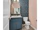 Charming powder room with stylish floral wallpaper, elegant mirror, and navy blue vanity at 295 Barbour Farm Ln, Four Oaks, NC 27524