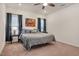 Bright bedroom with a ceiling fan, neutral walls, plush carpet, and natural light from two windows at 295 Barbour Farm Ln, Four Oaks, NC 27524